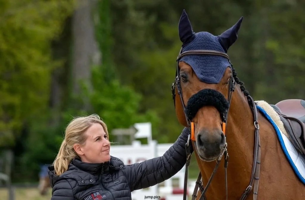 Lena Bieler mit einem braunen Pferd in Springausrüstung